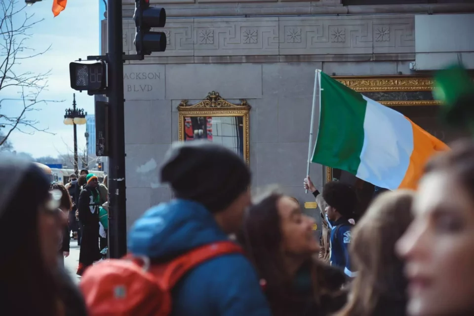 A group of people on the street with the Irish flag