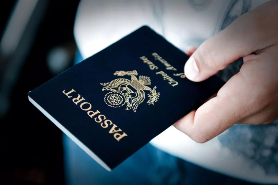 A man holding a US passport before moving internationally 