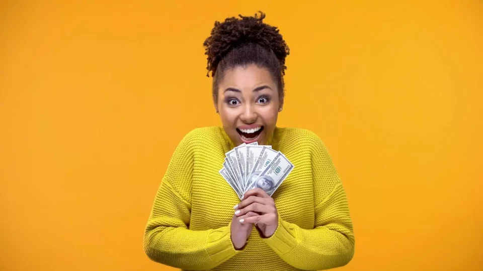 Joyful woman holding a bunch of dollar bills