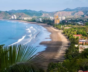 Costa Rican shore with a city and mountains in the background