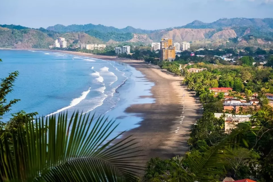 Costa Rican shore with a city and mountains in the background