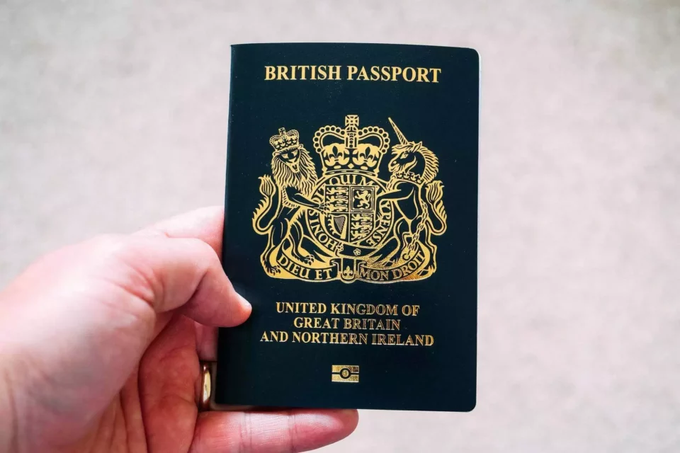 Man holding a UK passport after moving internationally  