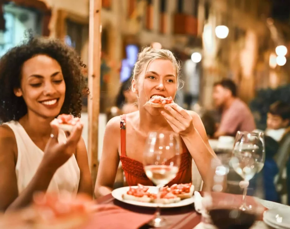 two girls eating at a restaurant and enjoying themselves after moving internationally