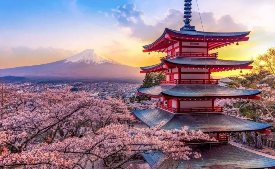 a view of a temple and Mount Fuji in Japan, surrounded by cherry blossoms
