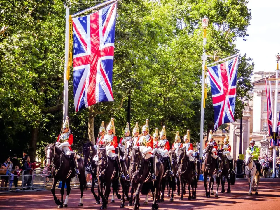 British army on horses passing by UK flags on lamp posts