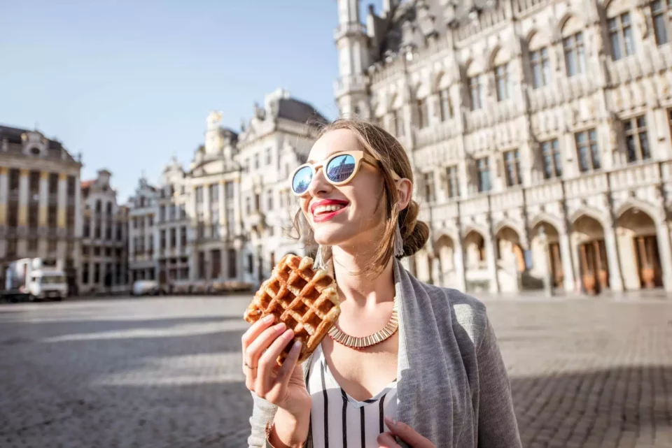  a happy woman tries Belgian waffles after international moving 