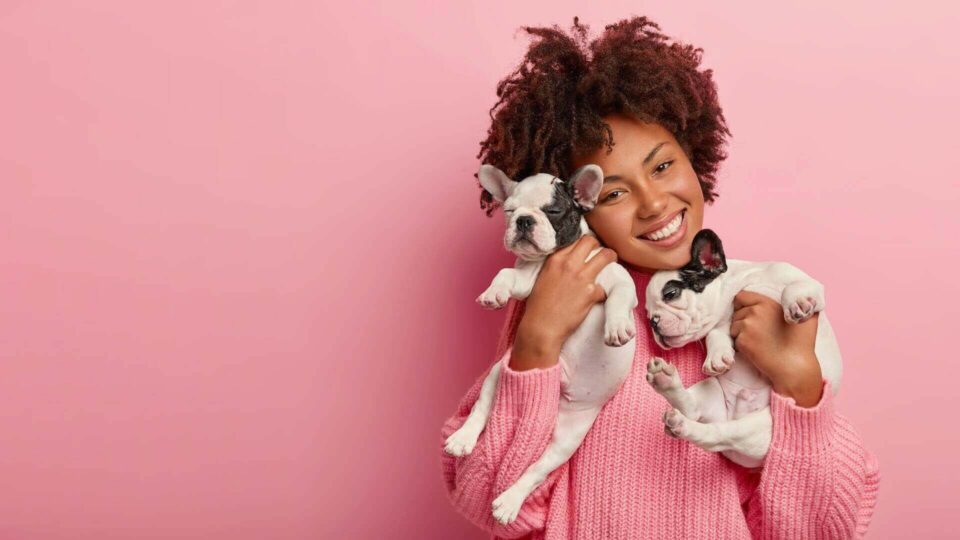 A woman holding two small dogs before moving internationally
