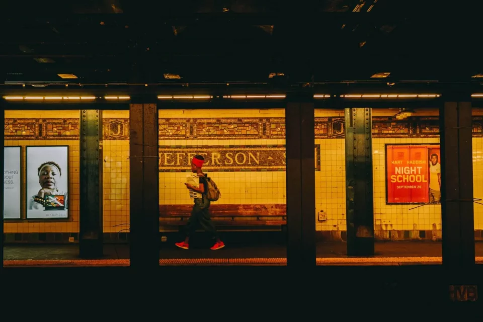 A girl with a bandana walking through the subway station