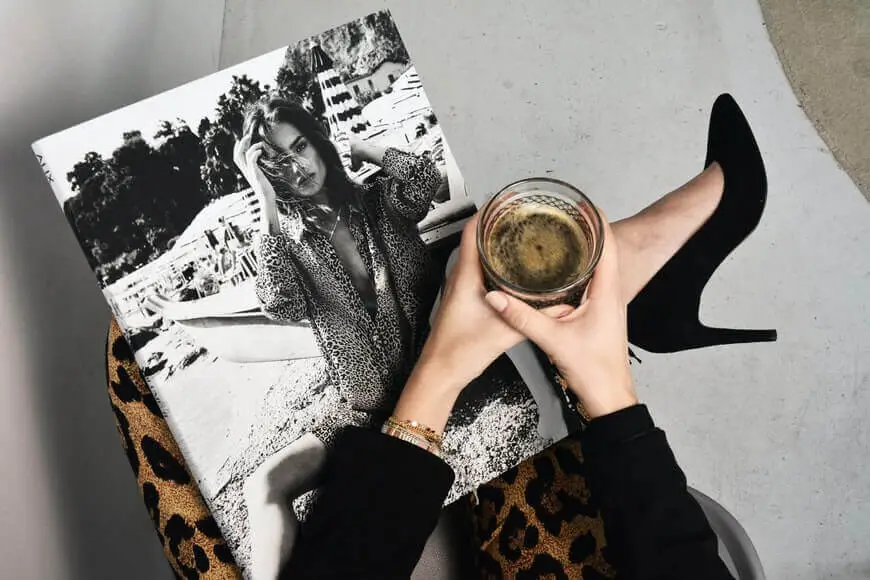 Woman reading a fashion magazine while drinking coffee