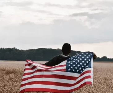 man in a field with a flag