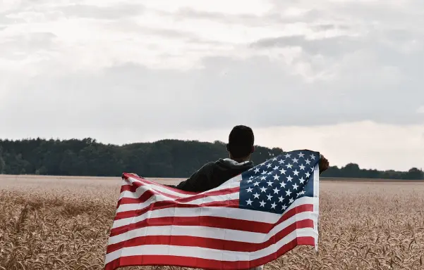 man in a field with a flag