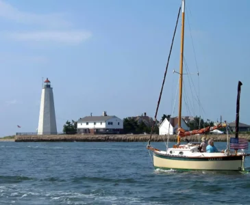 couple sailing by a lighthouse