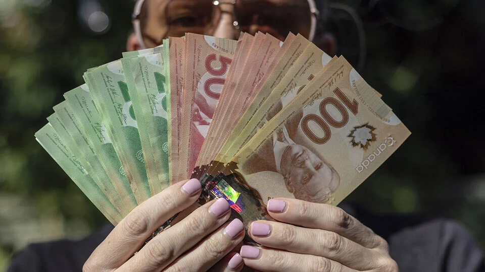 person holding Canadian money