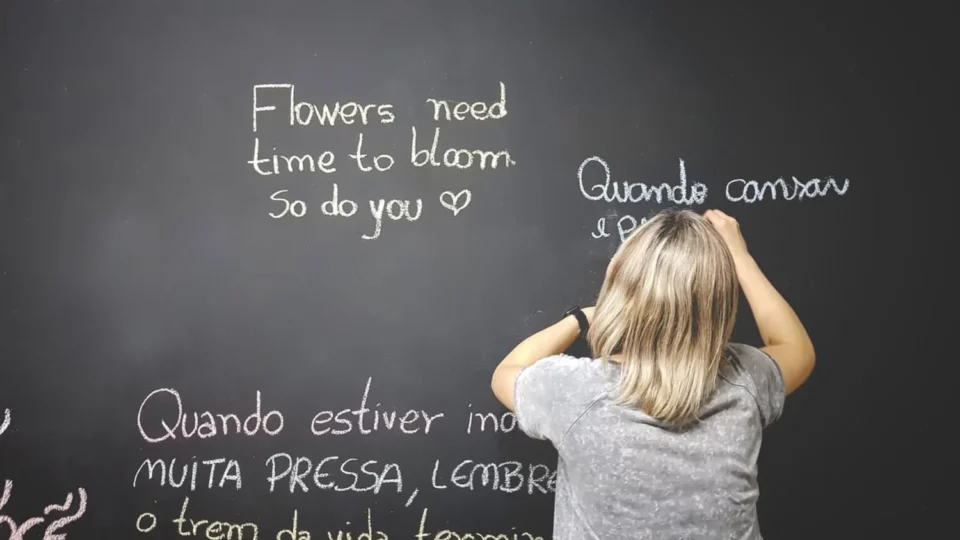 Girl writing on a blackboard in various languages