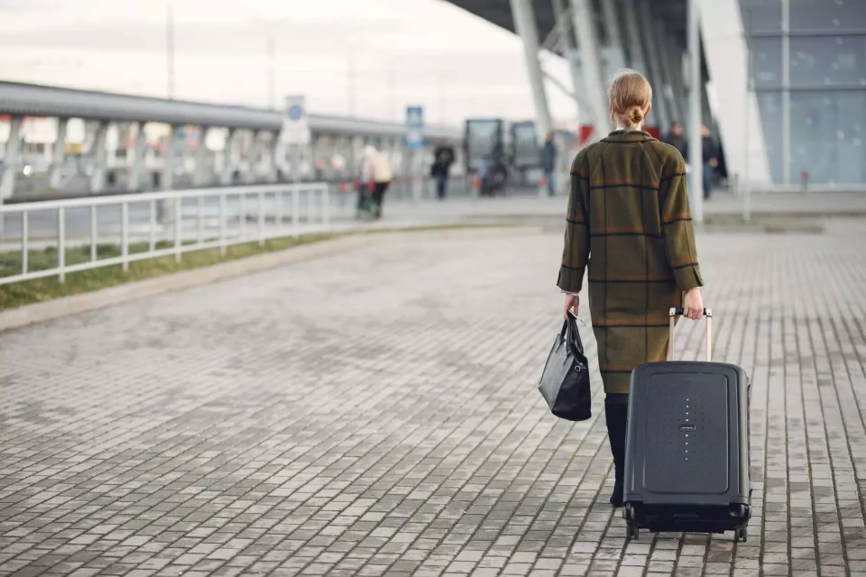 A woman walking with a suitcase before moving internationally