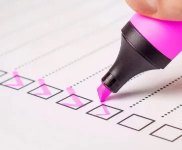A person marking a moving abroad checklist