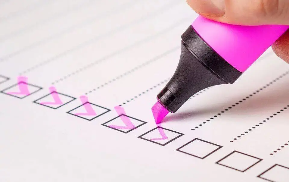 A pink marker checking boxes on a paper after moving internationally