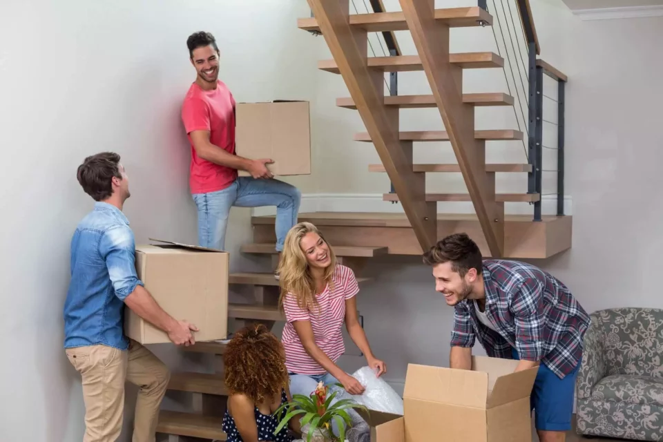 Five people carrying boxes up the stairs after moving abroad together with an overseas moving company 