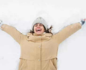 Woman smiling in winter gear after moving abroad