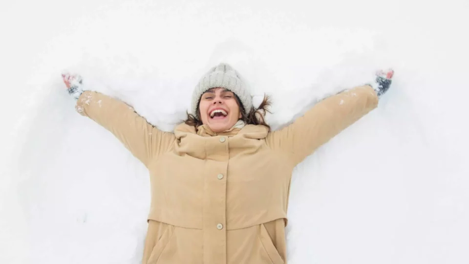 Woman smiling in winter gear after moving abroad 