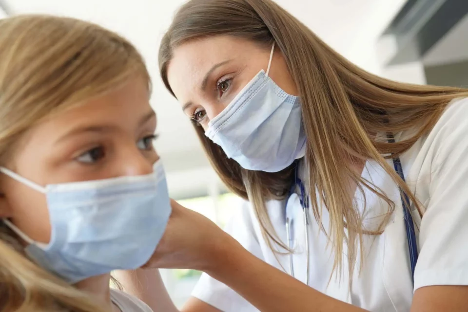 A doctor with a mask examining a girl