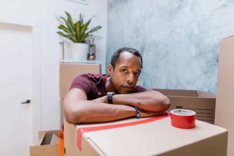 A serious man leaning on a box 