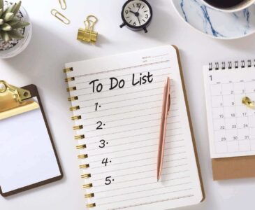 A to-do list, pen, plant, and calendar on the table
