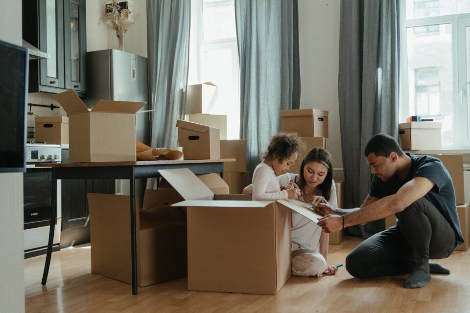 Couple sitting on the floor surrounded by boxes  