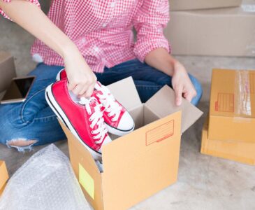 young start up small business owner packing shoes in the box at workplace. freelance woman entrepreneur SME seller prepare product for packaging process at home. Online selling, internet marketing, e-commerce concept
