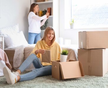 Female student unpacking things in dorm room on moving day