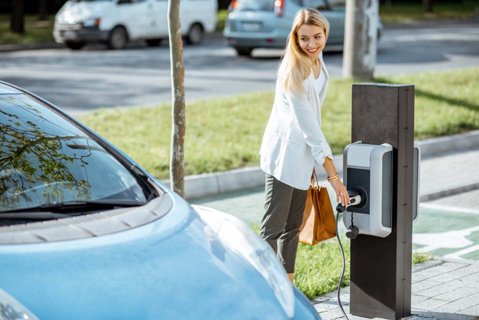 A girl charging an electric vehicle