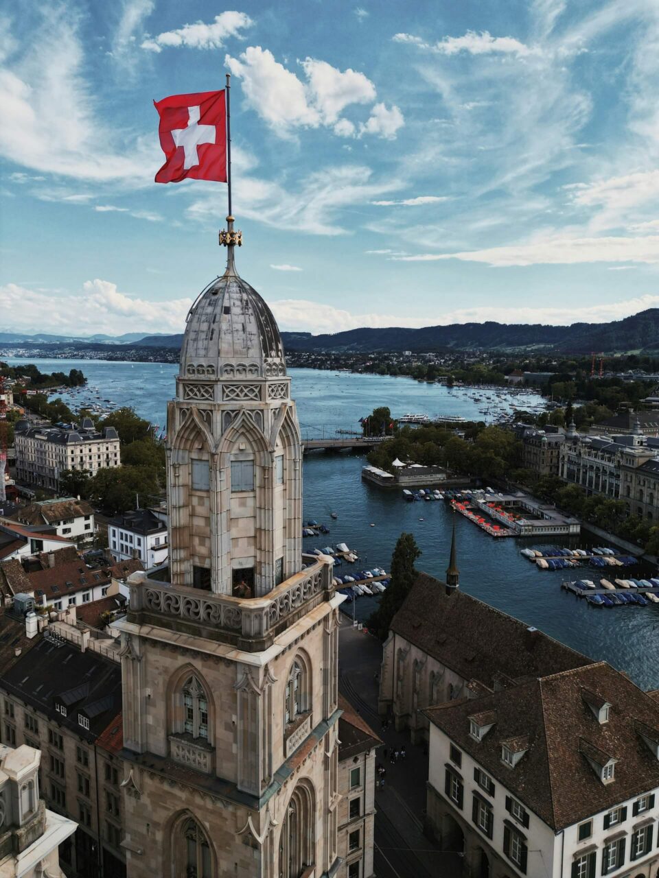 Large historic building with a flag by the water in Zurich Switzerland.