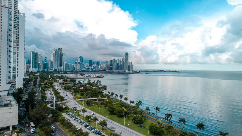 A scenic view of a large body of water with a city skyline and distant mountains in the background.