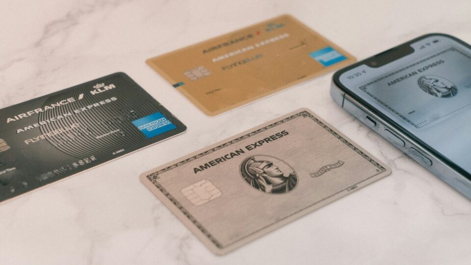 Credit cards lying on a table next to a smartphone displaying digital payment apps.
