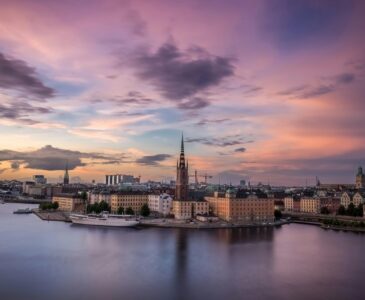 Riddarholmen Church spire standing tall above waterfront buildings in Stockholm, Sweden.