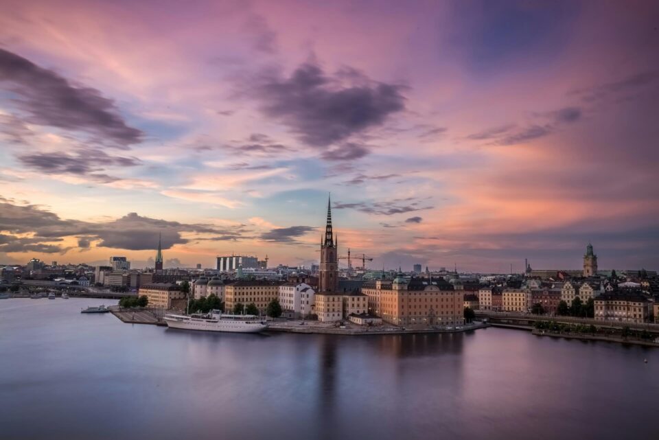 Riddarholmen Church spire standing tall above waterfront buildings in Stockholm, Sweden.